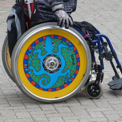 Photo d'un fauteuil roulant aux roues pleines et colorées.